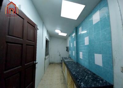 Compact kitchen with marble countertop and blue tiled wall