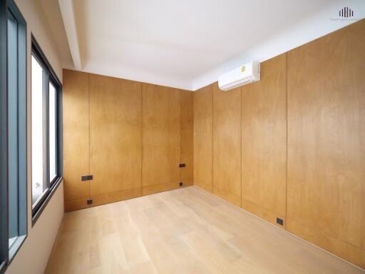 Bright, empty bedroom with wooden wall panels