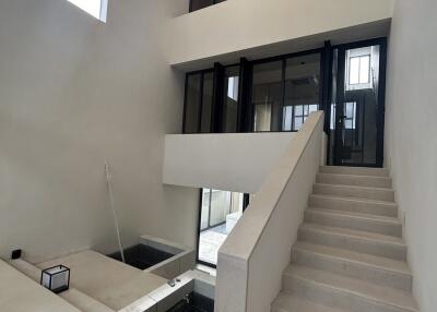 Modern multi-level residential interior with staircase and large windows