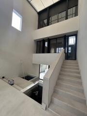 Modern multi-level residential interior with staircase and large windows