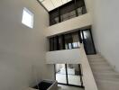 Interior view of a modern building with large windows and staircase