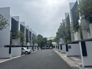 Modern row of townhouses with cars parked in front