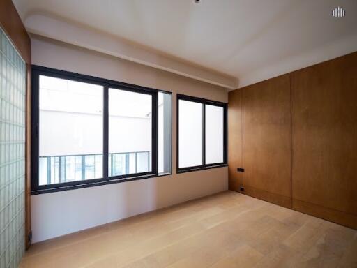 Bedroom with large windows and wooden flooring