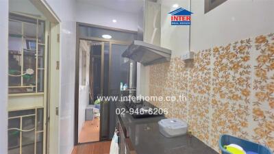 A modern kitchen with tiled backsplash and range hood