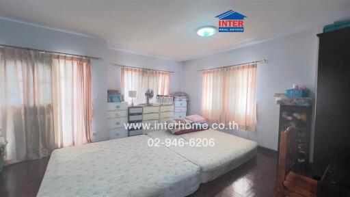 Spacious bedroom with large windows and ample storage