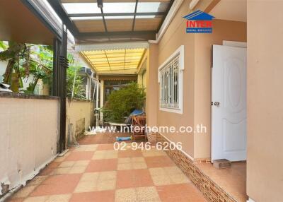 Covered outdoor pathway with plants and seating area