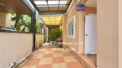 Covered outdoor pathway with plants and seating area