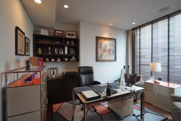 Spacious and well-lit home office with desk, chairs, and shelves