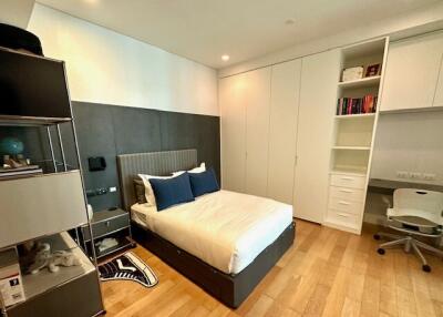 Modern bedroom with bed, built-in wardrobe, shelves, and study desk