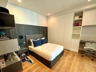 Modern bedroom with bed, built-in wardrobe, shelves, and study desk