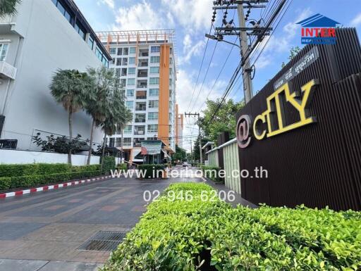 Exterior view of apartment building with sign and contact information