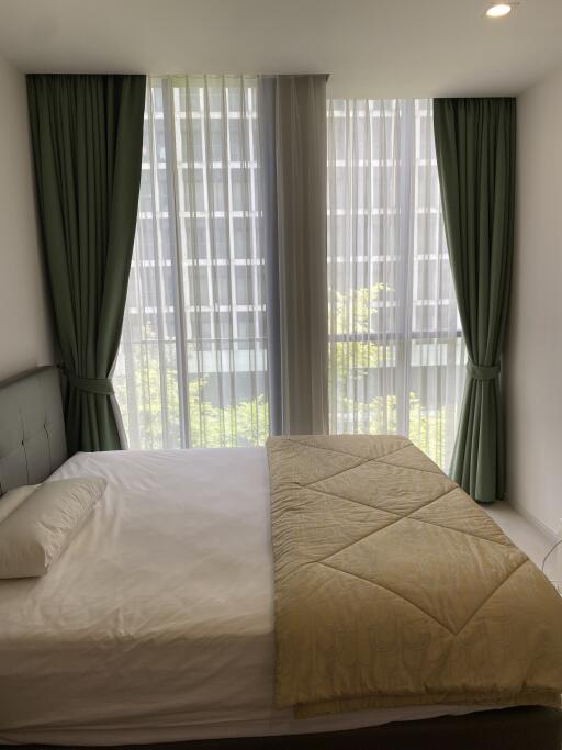 A modern bedroom with large windows and green curtains