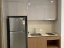 Compact modern kitchen with fridge, sink, and stove