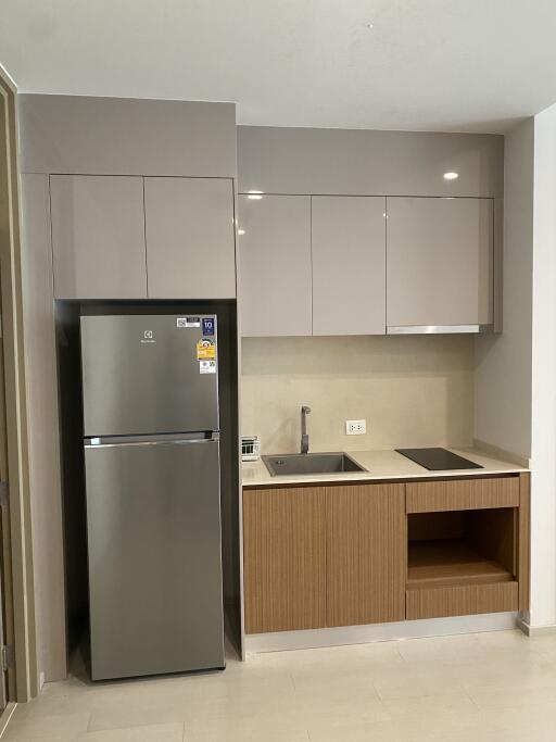 Compact modern kitchen with fridge, sink, and stove