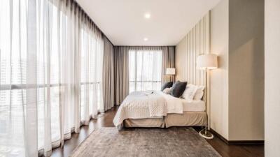 Modern bedroom with floor-to-ceiling windows and elegant decor