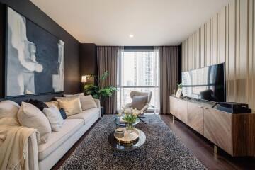 Modern living room with large TV, couch, coffee table, and a window view