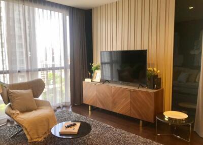 Modern living room with a large window, TV, armchair, and a coffee table