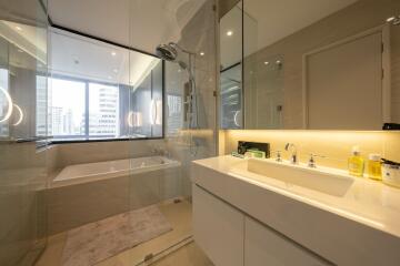 Modern bathroom with large window, glass shower, and bathtub