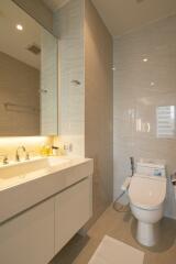 Modern bathroom with sink, mirror, and toilet