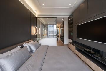 Modern bedroom with large bed, built-in cabinets, and wall-mounted TV