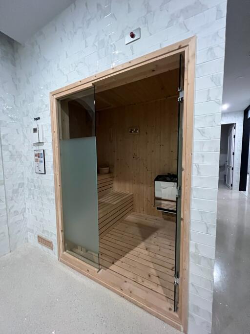 Indoor sauna room with glass door and wooden interior