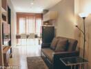 Living room with sofa, dining area, and natural light from windows