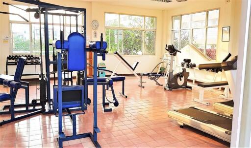 Well-equipped fitness room with various exercise machines and weights