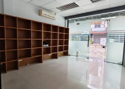 Interior view of commercial space with large windows and shelving