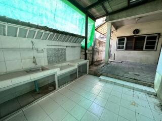 Outdoor kitchen area with sinks and tiled flooring