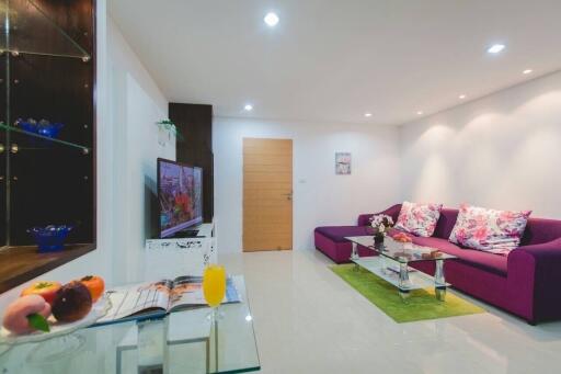 Modern living room with a purple sofa and glass coffee table