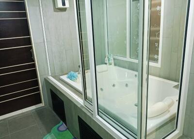 Modern bathroom with a jacuzzi and glass partition