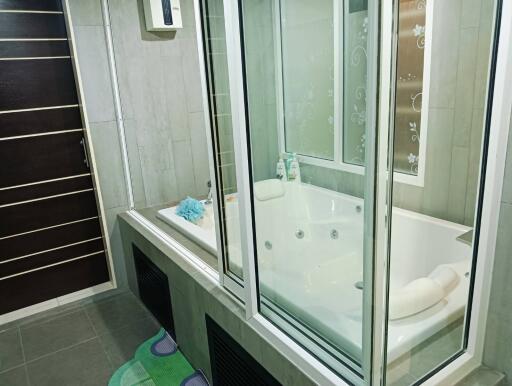 Modern bathroom with a jacuzzi and glass partition