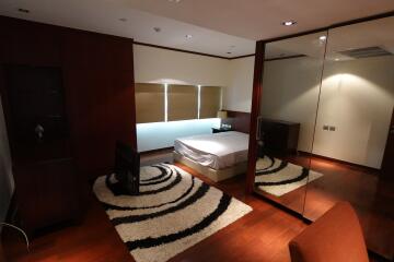 Modern bedroom with hardwood floors and large mirrored closet