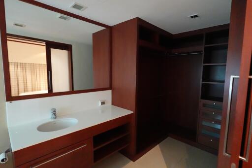 Modern bathroom with dark wood cabinetry and large mirror