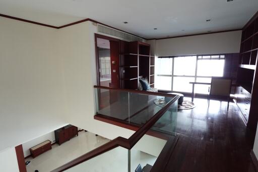 Mezzanine living area with glass railing and wooden finishes