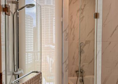 Modern bathroom with glass shower and city view