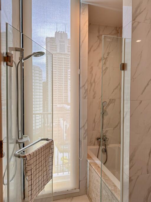 Modern bathroom with glass shower and city view