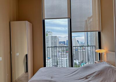 Spacious bedroom with large windows and city view