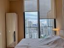 Spacious bedroom with large windows and city view