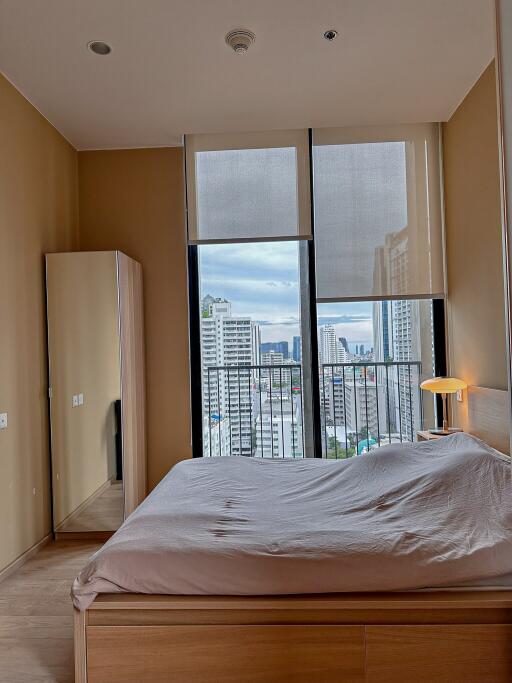 Spacious bedroom with large windows and city view