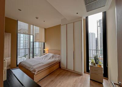 Modern bedroom with large windows and city view