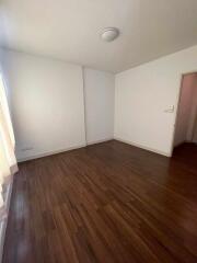 empty bedroom with wooden floors and a door