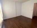 empty bedroom with wooden floors and a door