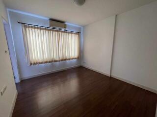 empty bedroom with wooden floor and large window