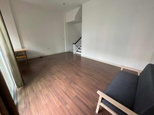 Spacious living room with wooden flooring and natural light