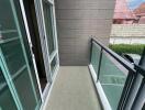 Small balcony with glass railing and tiled floor