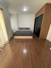 Bedroom with wooden flooring and a large bed