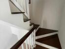 Indoor staircase with wooden steps and white handrails