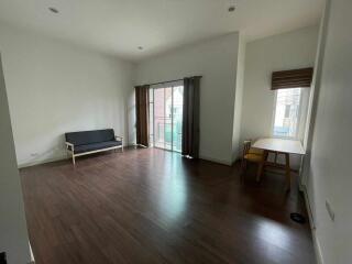 Spacious living room with wooden flooring and natural light