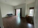 Spacious living room with wooden flooring and natural light